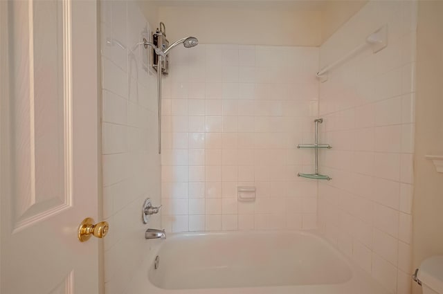 bathroom with tiled shower / bath combo and toilet