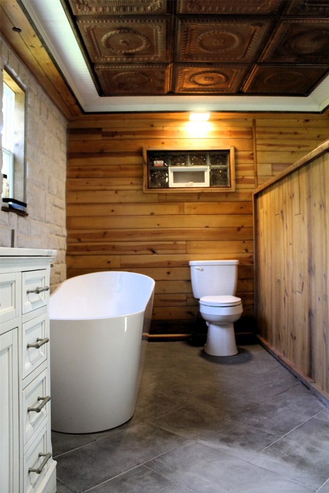 bathroom featuring tile patterned floors, toilet, and wooden walls