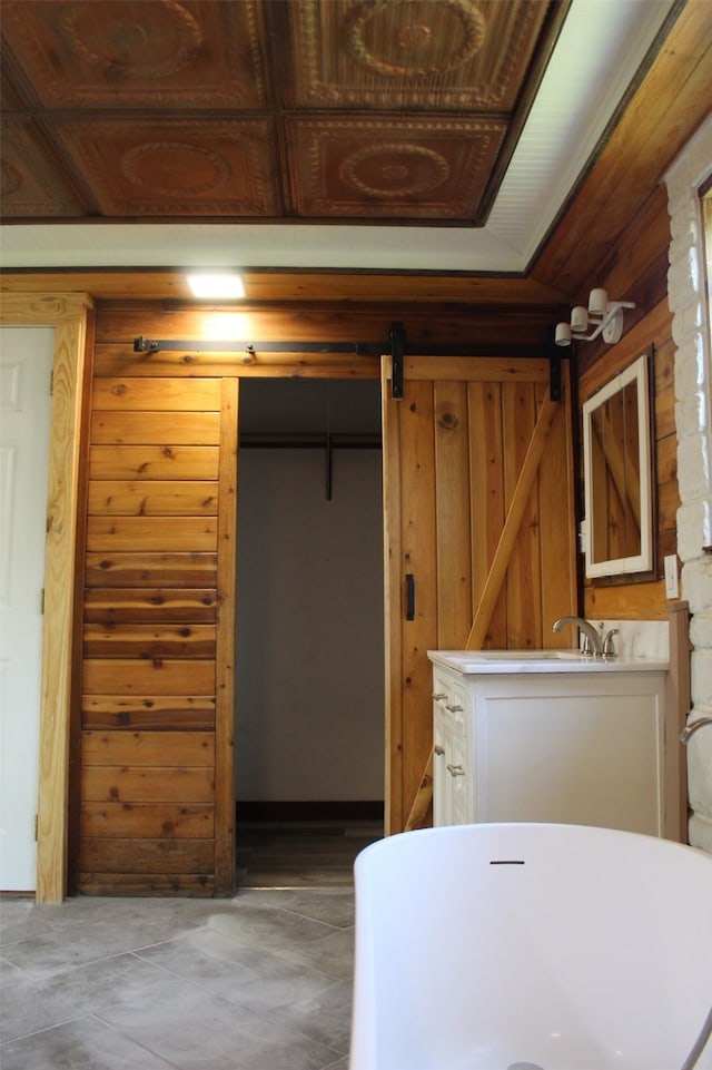 interior space with wood walls, wooden ceiling, and a barn door