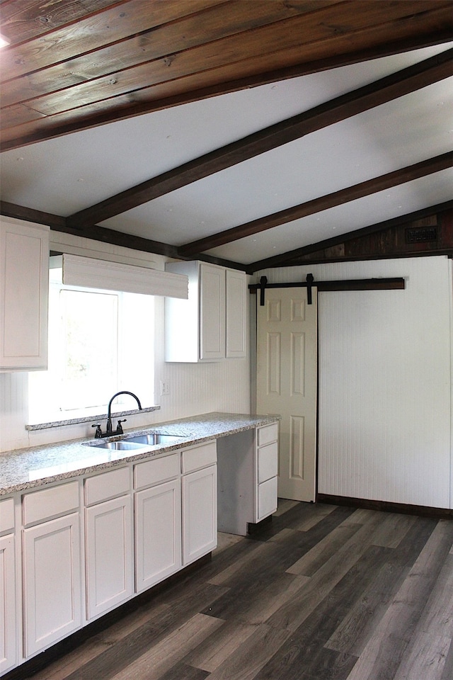 kitchen with sink, vaulted ceiling with beams, and white cabinetry