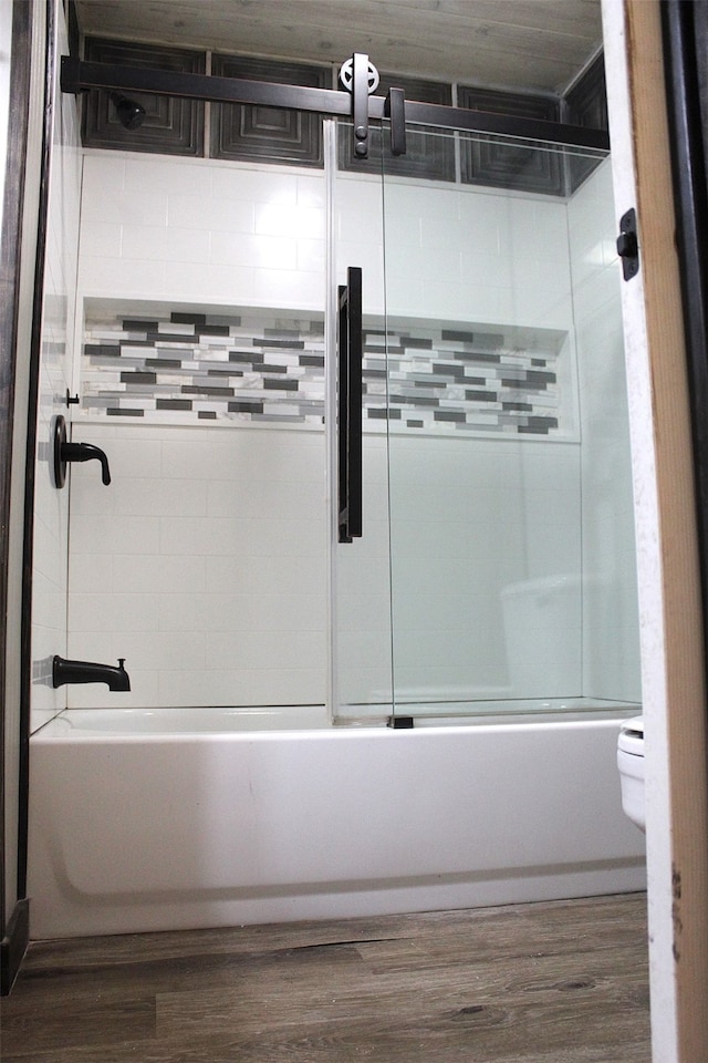 bathroom featuring shower / bath combination with glass door, toilet, and hardwood / wood-style floors