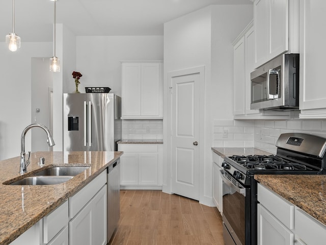 kitchen featuring sink, light stone countertops, white cabinets, and appliances with stainless steel finishes