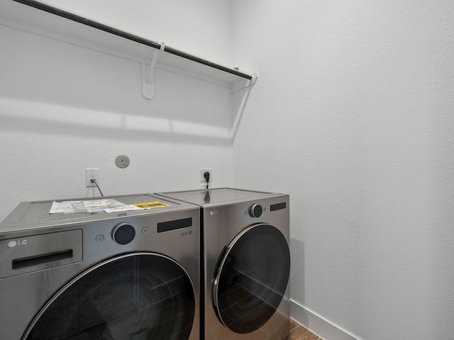 laundry room featuring wood-type flooring and independent washer and dryer