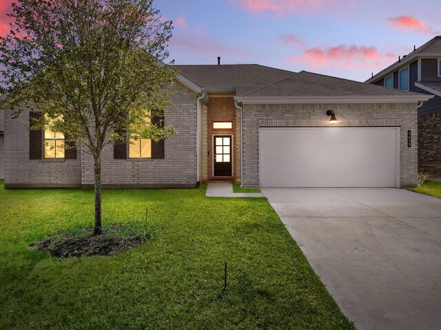 view of front facade featuring a lawn and a garage