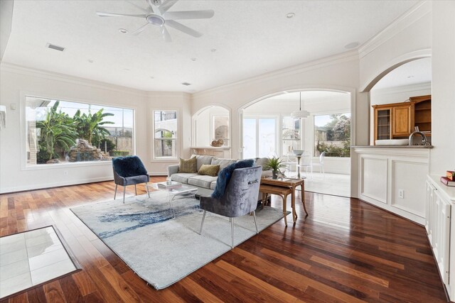 living room featuring ceiling fan, crown molding, hardwood / wood-style flooring, and sink