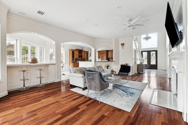 living room featuring ceiling fan, french doors, ornamental molding, and hardwood / wood-style flooring