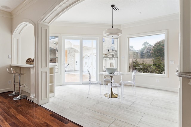 dining space with light wood-type flooring and crown molding