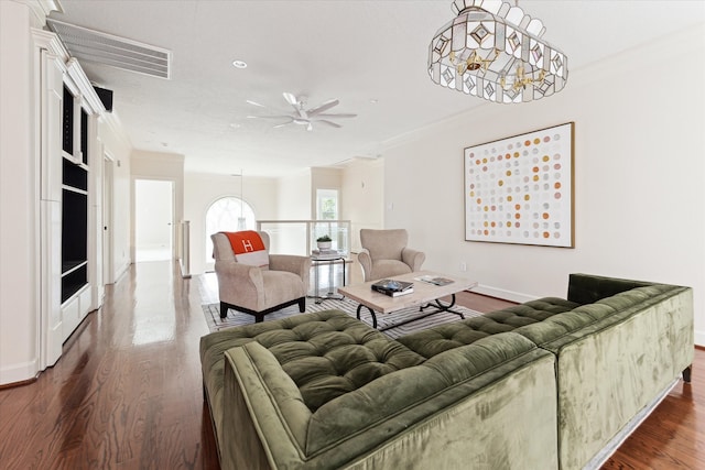 living room with ornamental molding, dark wood-type flooring, and ceiling fan