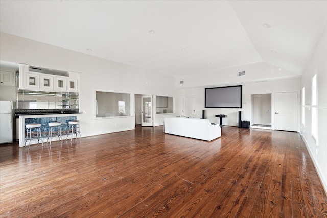 unfurnished living room featuring vaulted ceiling and hardwood / wood-style flooring