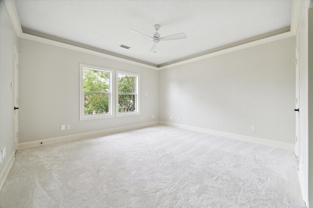 spare room featuring ceiling fan, ornamental molding, and light colored carpet