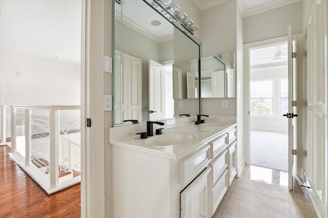 bathroom with crown molding, wood-type flooring, and double vanity