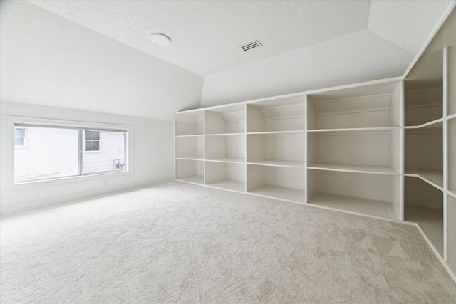 interior space featuring carpet flooring and vaulted ceiling