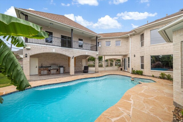 view of pool featuring area for grilling, a patio, and exterior kitchen