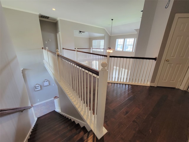 stairs with wood-type flooring and crown molding