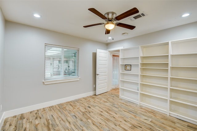 empty room with ceiling fan and light hardwood / wood-style floors