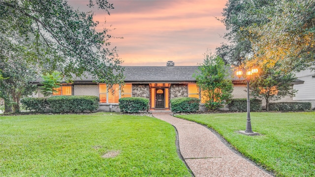 ranch-style home with a lawn