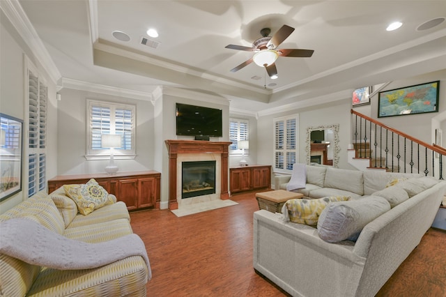 living room featuring hardwood / wood-style floors, a raised ceiling, and plenty of natural light