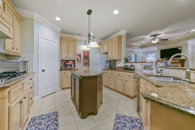 kitchen featuring crown molding, appliances with stainless steel finishes, ceiling fan, sink, and a center island