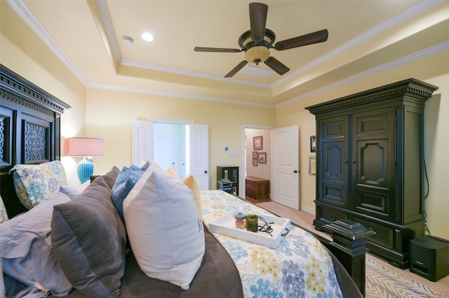 bedroom featuring ceiling fan, a raised ceiling, light colored carpet, and ornamental molding