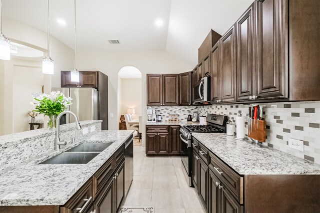 kitchen featuring decorative backsplash, pendant lighting, light tile patterned flooring, appliances with stainless steel finishes, and sink