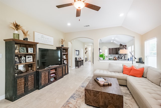 living room featuring ceiling fan, light tile patterned floors, and lofted ceiling