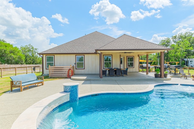 view of swimming pool featuring ceiling fan, pool water feature, a patio area, and an outdoor living space