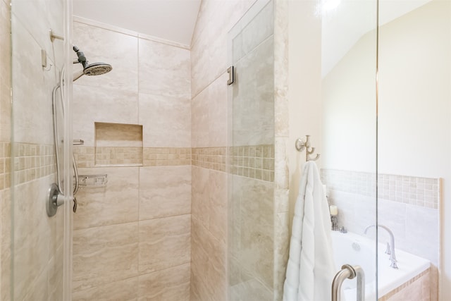 bathroom featuring lofted ceiling and separate shower and tub