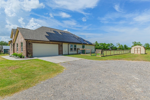 view of front of home featuring a front lawn, solar panels, and a garage