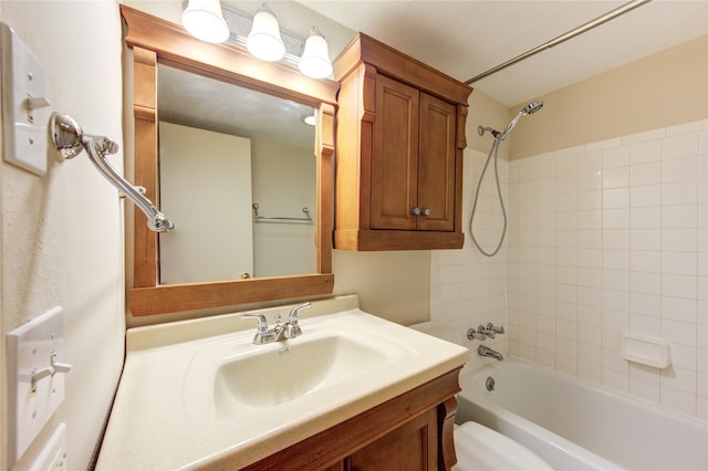 full bathroom featuring tiled shower / bath, toilet, and vanity