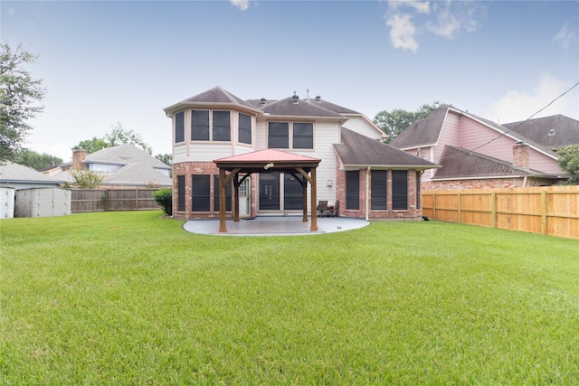 back of house with a fenced backyard, a gazebo, a patio area, and brick siding