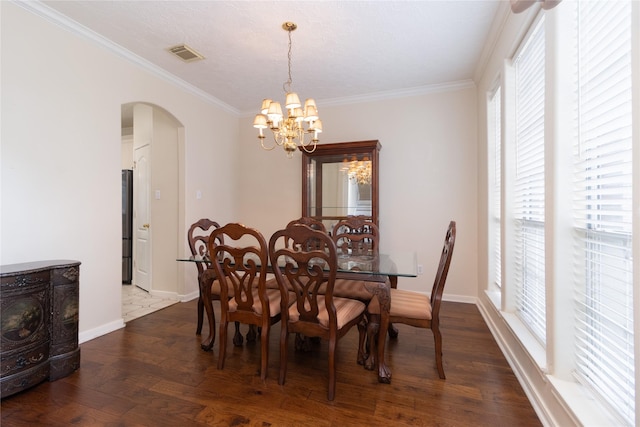 dining room with an inviting chandelier, arched walkways, dark wood-style flooring, and crown molding
