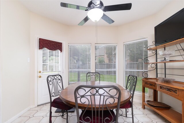 dining area featuring baseboards, a ceiling fan, and light floors
