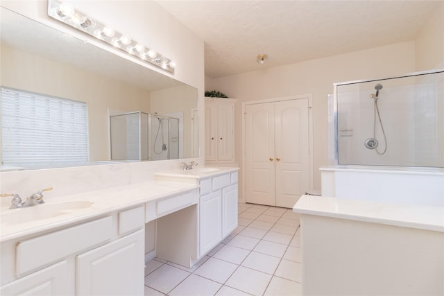 full bath with double vanity, a sink, tile patterned floors, and a shower stall