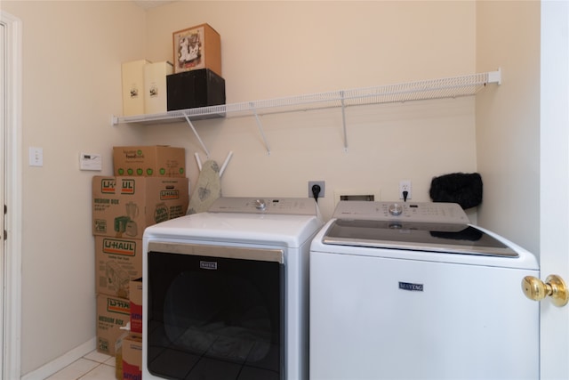 laundry area with light tile patterned floors and washer and clothes dryer