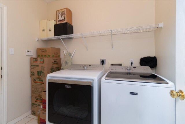 laundry room featuring laundry area, baseboards, independent washer and dryer, and light tile patterned floors