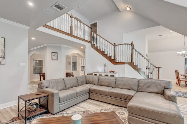 living room with high vaulted ceiling, ornamental molding, a notable chandelier, and light wood-type flooring