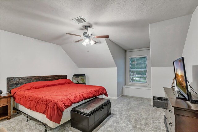 carpeted bedroom with a textured ceiling, ceiling fan, and lofted ceiling