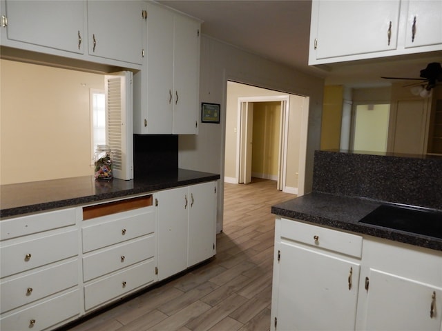 kitchen with decorative backsplash, white cabinets, ceiling fan, and light hardwood / wood-style floors