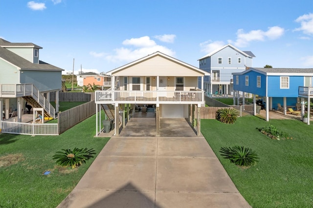 raised beach house with driveway, a residential view, stairs, a carport, and a front yard