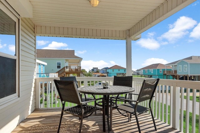 view of wooden balcony with a residential view, outdoor dining area, and a wooden deck