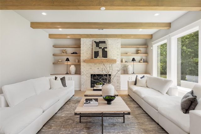 living room featuring hardwood / wood-style flooring, built in features, a fireplace, and beamed ceiling