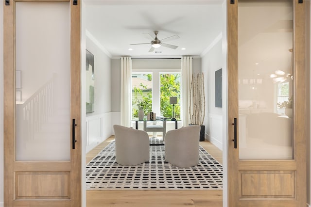 dining room with hardwood / wood-style flooring, ceiling fan, and crown molding