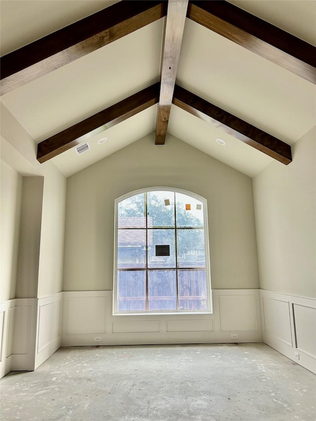 empty room featuring vaulted ceiling with beams and a healthy amount of sunlight