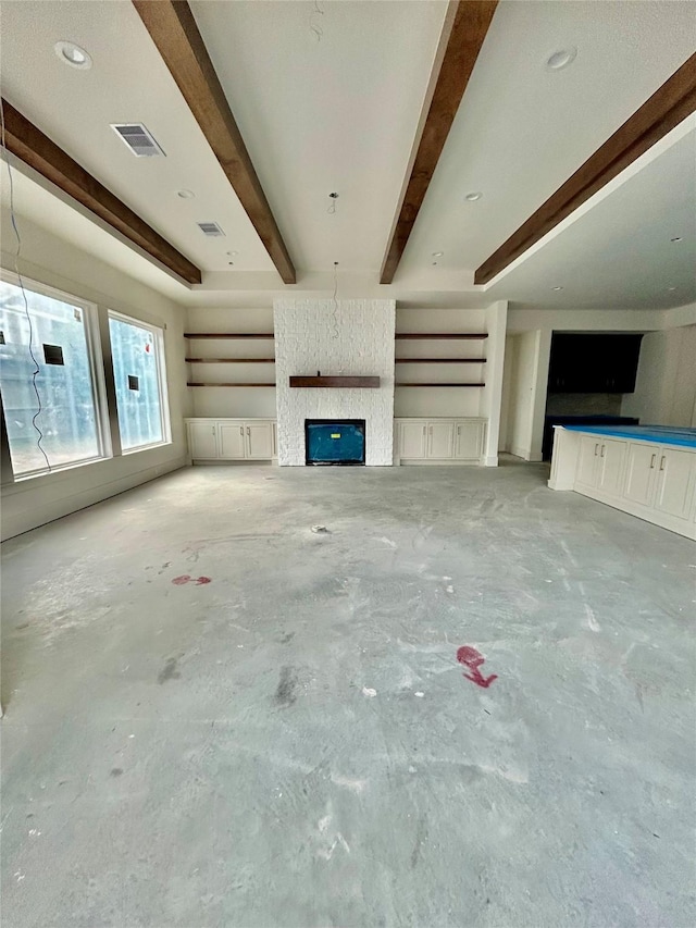 unfurnished living room with beamed ceiling and a fireplace