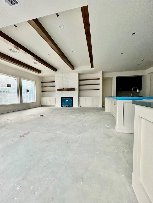 unfurnished living room featuring a large fireplace and beamed ceiling