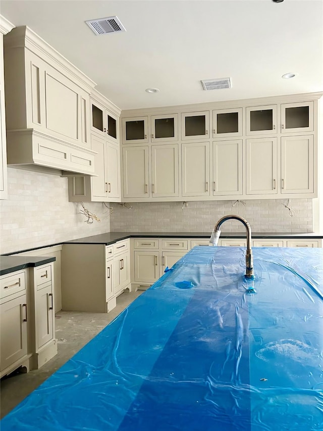 kitchen featuring sink, white cabinets, and concrete flooring