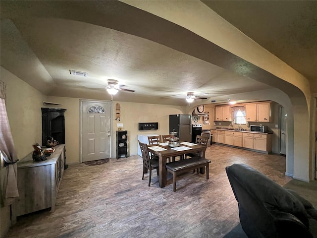 dining space with sink, ceiling fan, a textured ceiling, and hardwood / wood-style flooring