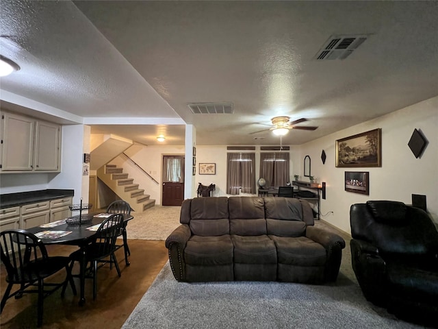 living room with ceiling fan, a textured ceiling, and carpet floors