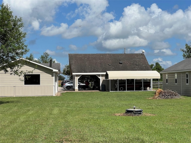 back of house with a lawn, a sunroom, and a carport