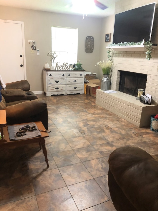 tiled living room featuring ceiling fan and a brick fireplace